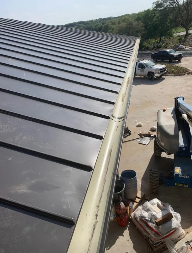Standing seam panel and gutter detail on a metal roofing jobsite in Worthington